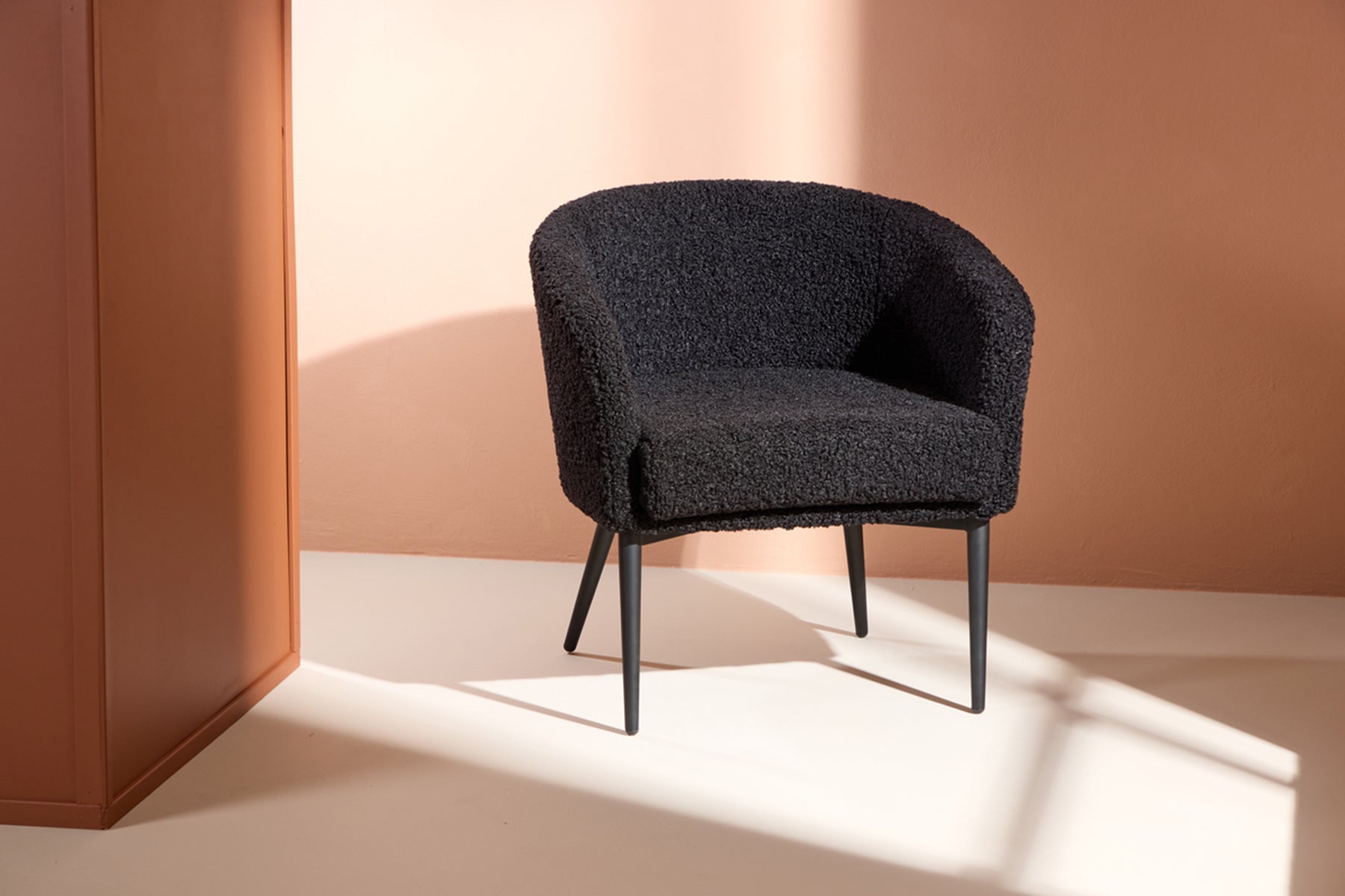 Elegancki fotel Canatendy z czarnej tkaniny boucle - idealny do relaksu w salonie.